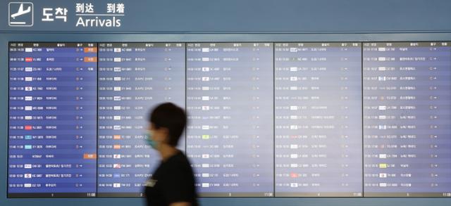 3일 인천국제공항 제1터미널 입국장에서 한 이용객이 도착 정보가 담긴 전광판 앞을 지나고 있다. 연합뉴스