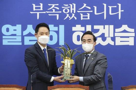 더불어민주당 박홍근 신임 원내대표가 25일 서울 여의도 국회 원내대표 회의실에서 김한규 당시 대통령비서실 정무비서관으로부터 문재인 대통령의 축하 난을 받고 있다. 연합뉴스