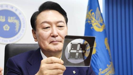 윤석열 대통령이 7일 용산 대통령실 청사 영상회의실에서 열린 국무회의에서 반도체 포토마스크를 보고 있다. 윤 대통령은 이날 교육부를 질타하며 과학기술 인재 양성 방안을 주문했다. 대통령실 제공