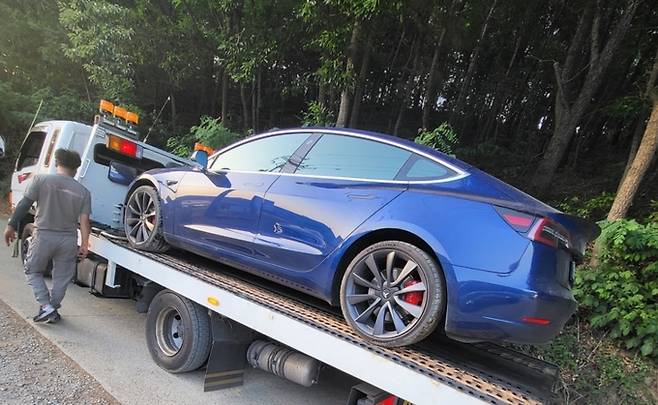 주행 중 돌을 밝고 냉각수관이 파손된 테슬라 ‘모델3’ 차량이 견인되고 있다. 제보자 제공