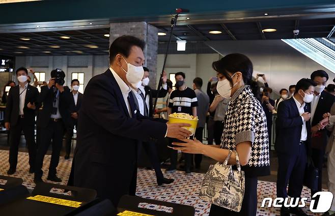 윤석열 대통령이 12일 오후 서울 메가박스 성수점에서 제75회 칸 국제영화제 남우주연상(송강호) 수상작 영화 '브로커'를 관람하기 전 부인 김건희 여사에게 팝콘을 주고 있다. (대통령실 제공) 2022.6.12/뉴스1 ⓒ News1 안은나 기자