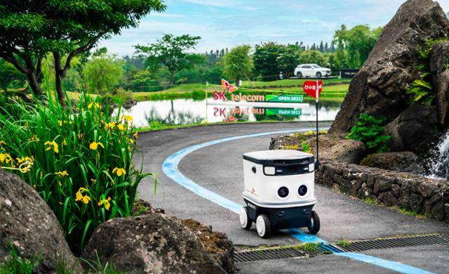 자율주행 배달로봇 뉴비가 제주도에 위치한 SK 핀크스 골프클럽을 주행하고 있다. 뉴비는 골프장을 오가며 선수와 관객들에게 물과 음료를 제공했다. SK텔레콤 제공