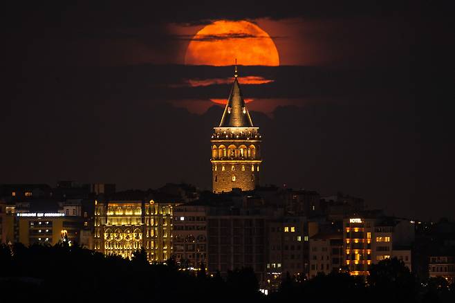 14일(현지 시각) 터키 이스탄불의 갈라타 타워 뒤에 슈퍼문이 떠오르고 있다. / AP 연합뉴스