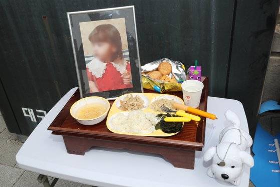 경북 구미에서 방치돼 숨진 3세 여아 친모 A씨의 첫 재판이 열린 지난해 4월 22일 오전 대구지방법원 김천지원 정문 앞에서 대한아동학대방지협회 회원들이 숨진 여아를 추모하기 위해 사진 앞에 차려 놓은 밥상이 눈길을 끌고 있다. 뉴스1