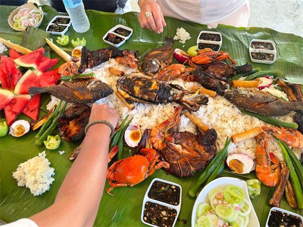 테이블에 바나나 잎을 깔고 그 위에 음식을 쏟아내 손으로 즐기는 필리핀식 식사.