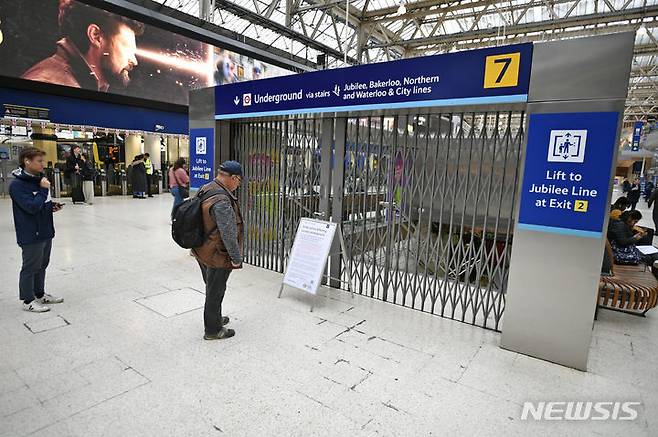 [런던=AP/뉴시스] 지난 6일(현지시간) 영국 런던 지하철 워털루역 입구에서 승객이 철도해운노조(RMT) 파업 경고문을 읽고 있다. 2022.06.20.