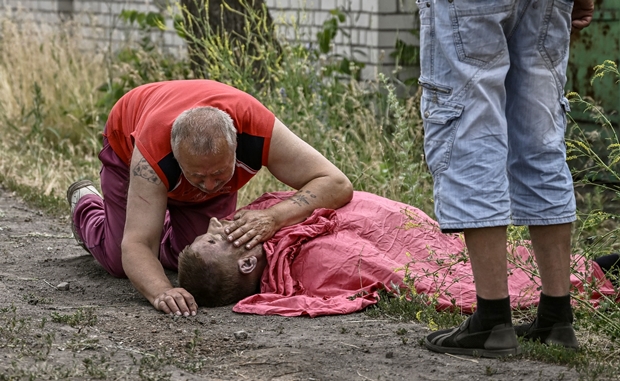 아버지의 날을 하루 앞둔 18일(이하 현지시간) 우크라이나 동부 루한스크주 리시찬스크에서 한 아버지가 러시아군 집속탄 공격에 숨진 아들의 시신을 붙잡고 오열하고 있다./출처=AFP 연합뉴스