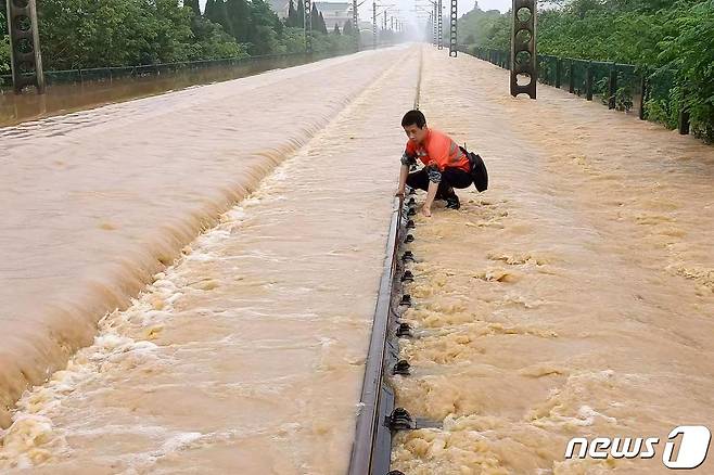 21일(현지시간) 폭우가 내려 홍수가 발생한 중국 장시성 상라오에서 물에 잠긴 철로를 직원이 점검을 하고 있다. © AFP=뉴스1 © News1 우동명 기자