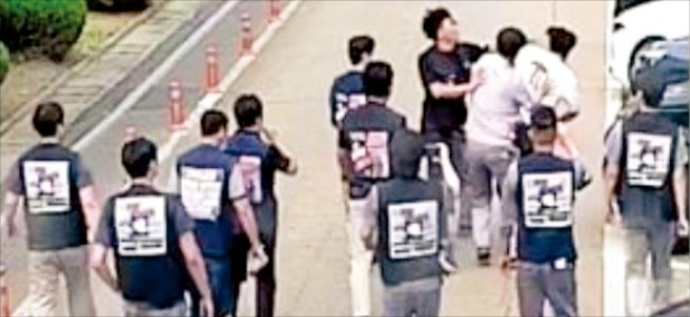 < 멱살 잡고 주먹질 > 검은 옷을 입은 한국타이어 노조원 10여 명이 지난 19일 대전공장에서 사측 담당 팀장들의 멱살을 잡고 몰아가고 있다.   독자 제공