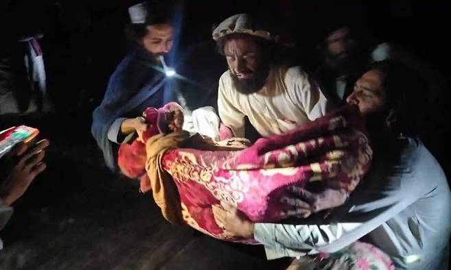 규모 6.1 강진이 일어난 아프가니스탄 파크티카주에서 한 주민이 부상자를 들어 옮기고 있다. AP연합뉴스