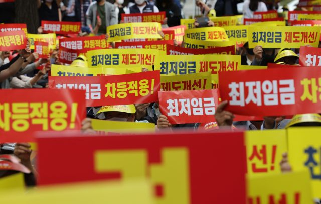 지난 8일 서울 국회의사당역 인근에서 열린 최저임금 제도개선 촉구 소상공인 결의대회에서 참가자들이 손팻말을 흔들고 있다. 연합뉴스