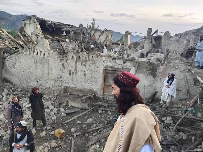 22일(현지시간) 아프가니스탄 팍티카주의 한 마을에서 주민들이 지진으로 파괴된 건물을 허탈한 표정으로 바라보고 있다. . /AP=뉴시스
