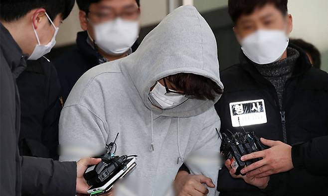 경찰의 신변보호를 받던 스토킹 피해 여성의 어머니를 살해한 이석준(가운데)이 지난해 12월 서울 송파경찰서에서 검찰로 송치되고 있다. 뉴시스
