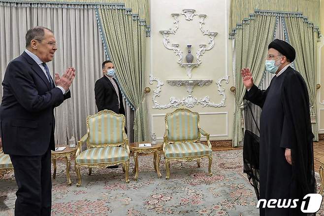 22일 세르게이 라브로프 러시아 외무장관이 에브라힘 라이시 이란 대통령과 만나 인사하고 있다. © AFP=뉴스1