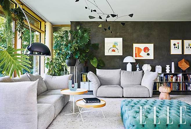 질서정연한 선과 그레이, 베이지, 톤다운된 화이트 등 미묘한 색상 변주로 예술적이고 편안하게 연출한 거실. 벽에 건 작품은 에우제니오 카르미(Eugenio Carmi)의 것.