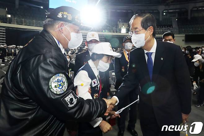 한덕수 국무총리가 25일 오전 서울 중구 장충체육관에서 열린 '6·25 전쟁 제72주년 기념행사'에 참석해 참전용사들과 악수를 나누고 있다. 2022.6.25/뉴스1 © News1 민경석 기자