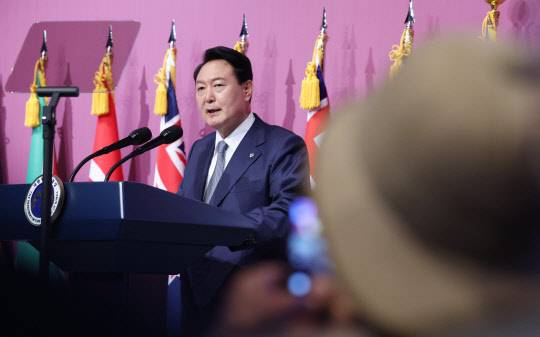 24일 서울 중구 신라호텔에서 열린 국군 및 유엔군 참전유공자 초청 오찬에서 한 에티오피아 참전용사가 윤석열 대통령의 인사말 순간을 촬영하고 있다.   연합뉴스