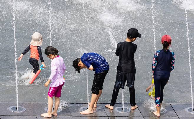 장맛비가 잠시 멈춘 25일 오후 서울 여의도 물빛광장에서 어린이들이 물놀이를 하고 있다. 이날 서울 지역 최고 기온은 30.3도를 기록했고, 습도가 높아 후텁지근한 날씨를 보였다. 연합뉴스