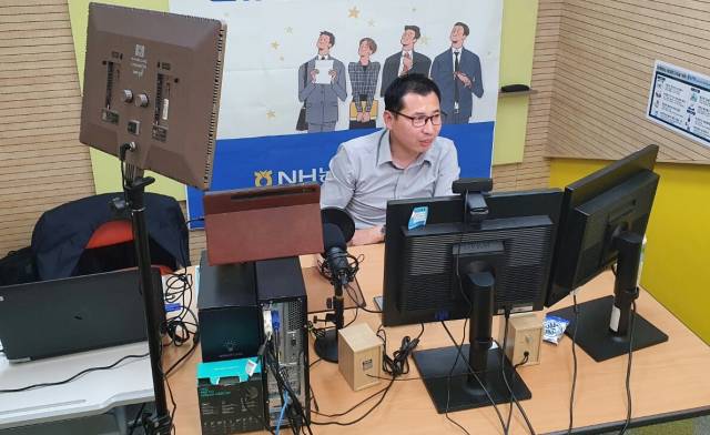 류승환 NH농협손보 영업교육팀 차장이 여러 대의 모니터와 마이크 앞에서 온라인 교육을 진행하고 있다. 사진 제공=농협손보