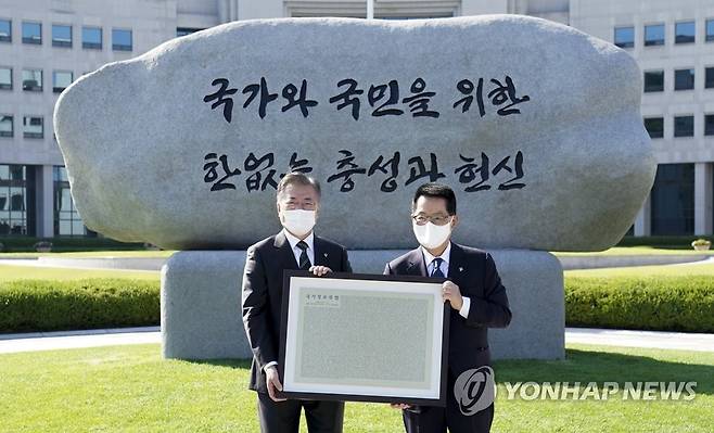 국정원 원훈석 제막식 참석한 문 대통령 (서울=연합뉴스) 문재인 대통령이 4일 오후 국가정보원에서 새로운 국정원 원훈석을 제막한 뒤 기념촬영하고 있다. 국정원 원훈은 5년 만에 '국가와 국민을 위한 한없는 충성과 헌신'으로 교체됐다. 2021.6.4 [청와대 제공. 재판매 및 DB 금지] cityboy@yna.co.kr