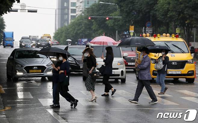 대기불안정으로 비가 오락가락 내리는 9일 오후 서울 서초구 서울중앙지법 인근 횡단보도에서 우산을 쓴 시민들이 발걸음을 재촉하고 있다. 2022.6.9/뉴스1 © News1 박세연 기자