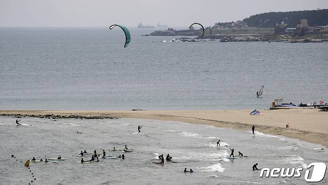 울산지역에 닷새째 폭염주의보가 이어지고 있는 23일 울산 울주군 진하해수욕장에서 동호인들이 서핑과 카이트 서핑을 즐기고 있다. 2021.7.23/뉴스1 © News1 윤일지 기자