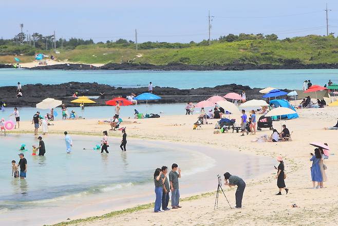 18일 제주시 구좌읍 김녕해수욕장에서 나들이객과 관광객들이 바닷가에서 바닷바람을 쐬거나 물놀이를 하며 휴식을 즐기고 있다./ 연합뉴스