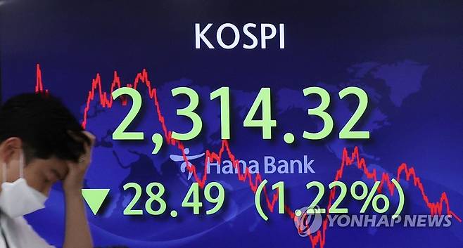 코스피와 코스닥이 이틀 연속 연저점으로 추락한 지난 23일 오후 서울 중구 하나은행 본점 딜링룸에서 직원이 전광판 앞을 지나고 있다. [연합뉴스 자료사진]