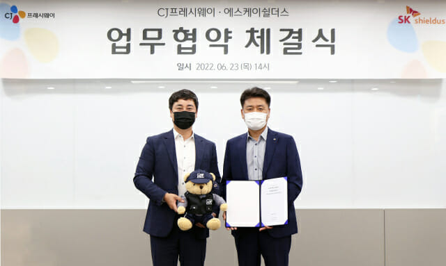 지난 23일 서울 상암동 CJ프레시웨이 본사에서 SK쉴더스 김윤호 전략사업그룹장(왼쪽)과 CJ프레시웨이 강연중 전략사업본부장이 업무협약 체결 후 기념촬영을 하고 있다.