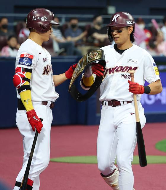 지난 19일 서울 고척스카이돔에서 열린 2022 프로야구 KBO리그 LG 트윈스와 키움 히어로즈의 경기. 4회말 1사 솔로 홈런을 터트린 키움 이정후가 더그아웃에서 송성문으로부터 챔피언 벨트를 건네 받고 있다. [연합뉴스]