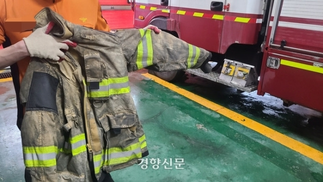 경기 화성의 한 119안전센터에서 근무하는 소방관이 지난 24일 까맣게 변한 방화복을 들어 보이고 있다. |김태희기자