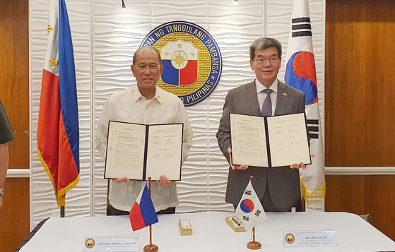 Korea Shipbuidling & Offshore Engineering President Ka Sam-Hyun, right, and Secretary of National Defense of the Philippines Delfin N. Lorenzana, left, stand for a photo session after the signing of a contract for six offshore patrol vessels on Monday at the Department of National Defense complex in Manila. [KSOE]