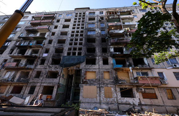 폭격에 살아 남았지만 남은 건 폐허 뿐 - 10일(현지시간) 우크라이나의 수도 키이우의 북쪽 외곽의 폭격 피해 아파트에서 한 주민이 완전히 파괴된 건물 앞에 서 있다. 이 아파트는 지난 3월 14일 러시아군의 폭격으로 극심한 피해를 본 곳으로 사상자가 다수 발생한 곳이다. 러시아의 우크라이나에 대한 공격이 동남부 돈바스 지역에 집중되면서 전쟁을 피해 키이우를 떠났던 시민들이 집으로 돌아오고 있지만, 폭격 피해지역의 주민들은  부서진 집에서 쓸 수 있는 가재도구만 수습하고 있다. 2022.6.11 연합뉴스