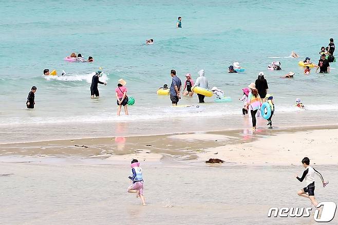 올해 첫 폭염주의보가 내린 26일 제주시 함덕해수욕장을 찾은 시민들이 물놀이를 즐기고 있다. 이곳을 포함한 제주지역 해수욕장 12곳은 7월1일 정식 개장한다.2022.6.26/뉴스1 © News1 홍수영 기자