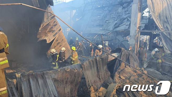 27일 (현지시간) 우크라이나 크레멘추크에서 러시아 군의 미사일 포격을 받아 아수라장이 된 쇼핑몰서 구조대원이 수색을 하고 있다. © AFP=뉴스1