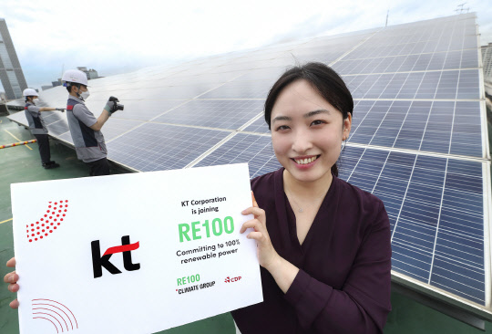 서울 관악구 KT구로타워 옥상에 설치된 태양광발전소에서 KT 직원이 RE100 가입을 알리는 기념사진을 촬영하고 있다. KT 제공