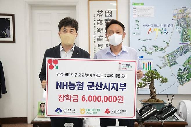 김대호 농협은행 군산시지부장(왼쪽)이 군산시청을 찾아 강임준 군산시장에게 장학금을 전달하고 기념촬영을 하고 있다. *재판매 및 DB 금지