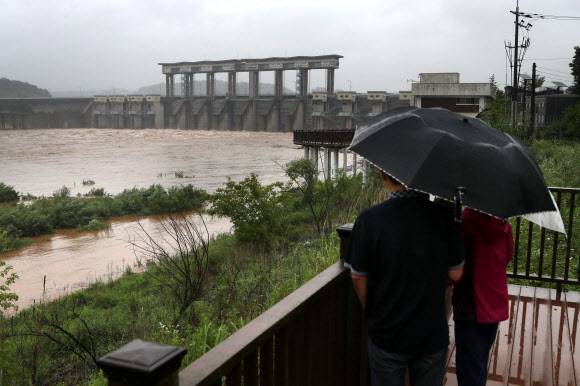 장마전선의 영향으로 북한 지역에 집중호우가 지속되는 가운데 28일 경기도 연천군 군남홍수조절댐에서 주민들이 방류 과정을 지켜보고 있다.연합뉴스
