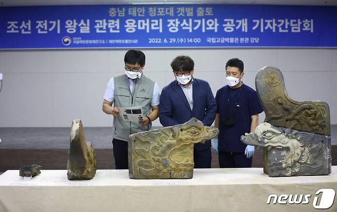 29일 서울 종로구 국립고궁박물관에서 열린 충남 태안 청포대 갯벌 출토 조선 전기 왕실 관련 용머리 장식기와 공개 기자간담회에서 관계자들이 용머리 장식기와를 살펴보고 있다. 2022.6.29/뉴스1 © News1 이광호 기자