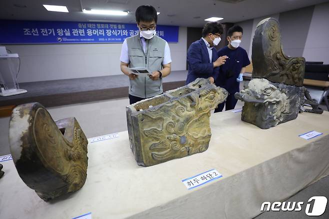29일 서울 종로구 국립고궁박물관에서 열린 충남 태안 청포대 갯벌 출토 조선 전기 왕실 관련 용머리 장식기와 공개 기자간담회에서 관계자들이 용머리 장식기와를 살펴보고 있다. 2022.6.29/뉴스1 © News1 이광호 기자
