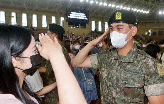코로나19 확산으로 2년 4개월 동안 중단됐던 논산 육군훈련소 가족 상봉 수료식이 29일 재개됐다. 신병 수료식에서 한 이등병이 여자친구에게 거수경례로 인사하고 있다. 프리랜서 김성태