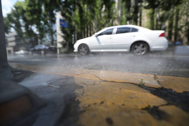 대구·경북 대부분 지역에 낮 최고 기온이 33도를 웃돌며 폭염특보가 내려진 지난 21일 대구 달구벌대로에 설치된 클린 로드 시스템에서 도로 열기를 식히는 물이 뿜어져 나오고 있다. 연합뉴스