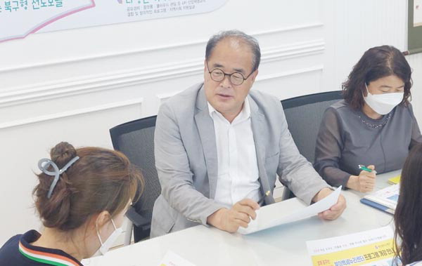 부산 북구 ‘북이백세누리센터’ 강이근(가운데) 센터장이 직원들과 센터 프로그램을 논의하고 있다.