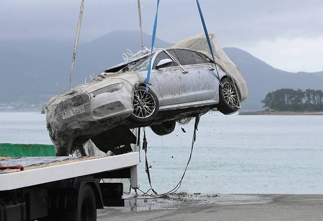 29일 오전 전남 완도군 신지면 송곡선착장 인근 방파제에서 관계자가 10ｍ 바닷속에 잠겨있는 조유나(10)양 가족의 차량을 인양한 뒤 조사를 위해 지상으로 옮기고 있다. 경찰은 실종된 조양의 가족과 차량을 찾기 위해 수중 수색하다 전날 가두리양식장 아래에 잠겨있는 차량을 발견했다. [연합]