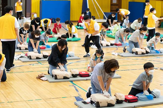 [수원=뉴시스] 29일 경기 수원시 영통구 매여울초등학교 강당에서 경기대학교 학생들이 초등생과 학부모를 대상으로 심폐소생술 교육을 진행하고 있다. 2022.06.29. (사진=경기대 제공) *재판매 및 DB 금지