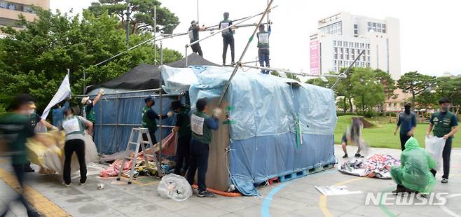 [전주=뉴시스] 김얼 기자 = 전북 전주시 전주시청 앞 천막농성장이 447일 만에 철거가 확정된 29일 민주노총 전국민주연합노동조합 관계자들이 분주하게 움직이며 농성장을 해체하고 있다. 2022.06.29. pmkeul@newsis.com