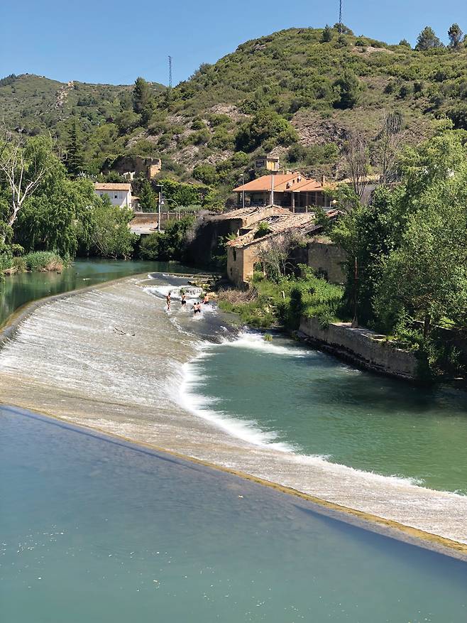 에스테야 입구의 강물에서 한 무리의 젊은이들이 시원스럽게 물놀이를 즐기고 있다.