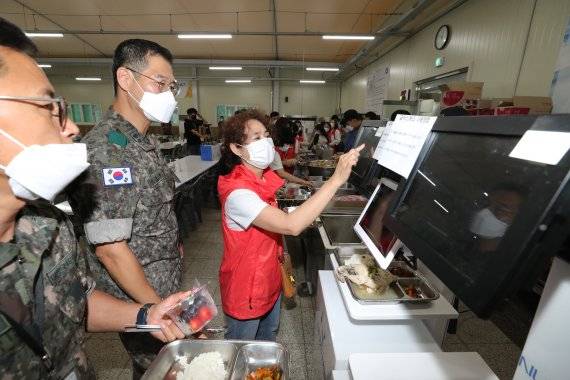 제7기 어머니 장병 급식·피복 모니터링단원들이 23일 경기 파주시 육군 9사단을 방문해 장병들과 급식자동측정시스템을 이용하고 있다. 사진=국방일보 제공