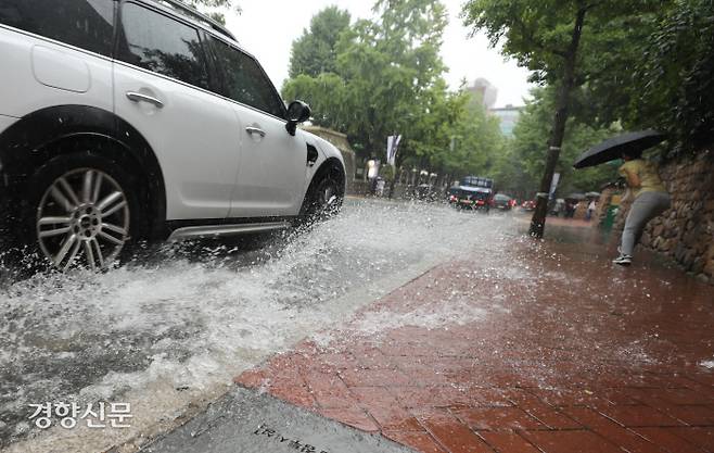 전국적으로 장맛비가 이어진 29일 기습적으로 장대비가 내린 29일 서울 정동길에서 차량 한 대가 도로 위에 고인 물을 튀기며 지나가고 있다. 강윤중 기자