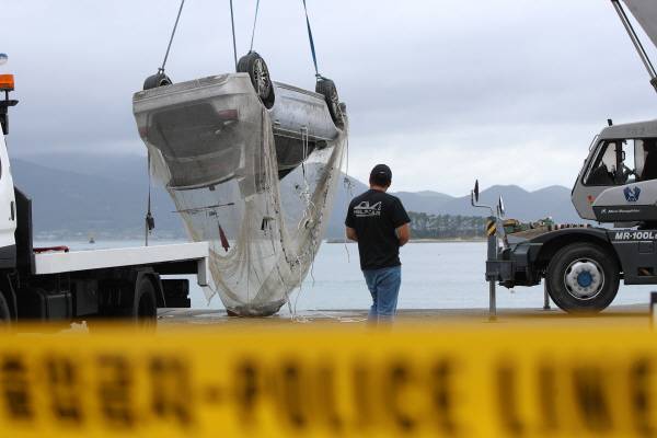 29일 오전 전남 완도군 신지면 송곡선착장 인근 방파제에서 관계자가 10ｍ 바닷속에 잠겨있는 조유나(10)양 가족의 차량을 인양한 뒤 조사를 위해 지상으로 옮기고 있다. 연합뉴스